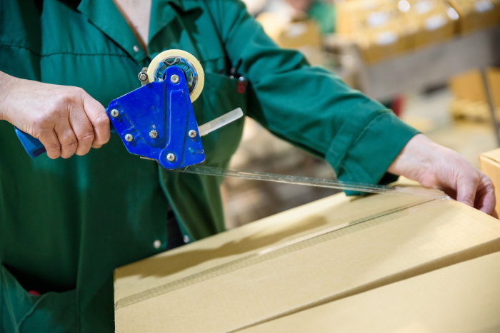 woman-applying-package-tape-to-box